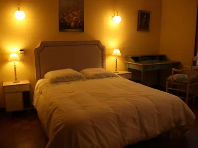 a bedroom with a bed with two lamps and a desk at Chambres d'hôtes Elisa & Etienne in Manosque
