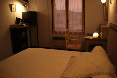 a bedroom with a bed and a desk and a window at Chambres d'hôtes Elisa & Etienne in Manosque