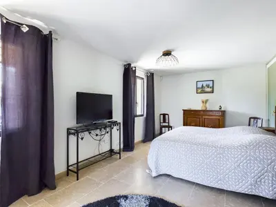 a bedroom with a bed and a flat screen tv at Villa rénovée à Eygalières avec piscine chauffée - FR-1-599-19 in Eygalières