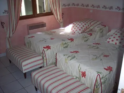 a bedroom with two twin beds and two chairs at bastide St Joseph in Eyguières