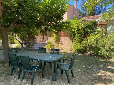 a green table and chairs under a tree at Maison provençale en campagne à Eguilles in Éguilles