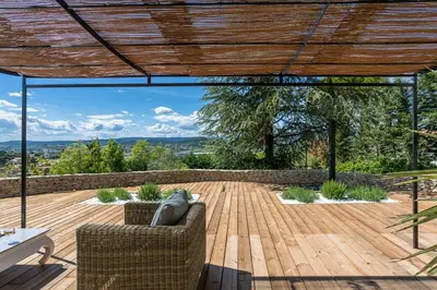 a patio with a wooden deck with a wooden pergola at Villa Domitia Chambre d'Hôtes Luberon in Bonnieux