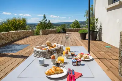a table with food and drinks on a deck at Villa Domitia Chambre d'Hôtes Luberon in Bonnieux