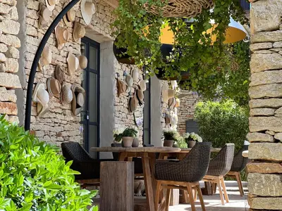 a patio with a wooden table and chairs at Le Mas de Béthel in Gordes