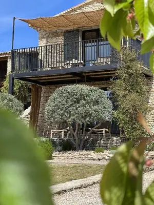 a building with a balcony and a tree at Le Mas de Béthel in Gordes