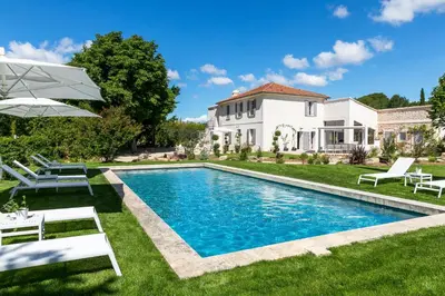 a villa with a swimming pool in front of a house at La Bastide de Damien, 5 clefs Demeure d'Exception et Table Remarquable dans le guide Teritoria, JACUZZI Privatif, Cuisine étoilée Dominique Frérard in Aix-en-Provence