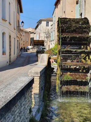 a water fountain in the middle of a street at Maison de village façon Loft, avec cour et airco, dans le centre historique in LʼIsle-sur-la-Sorgue