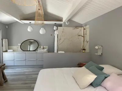 a bedroom with a white bed and a mirror at Le Cabanon de Modène version 2021 nature in Modène