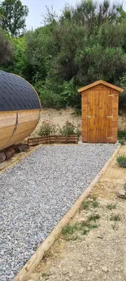 a small wooden shed and a wooden boat on gravel at Hébergements insolites - Détente en Luberon in Viens