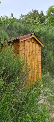 a wooden shed in the middle of a field of grass at Hébergements insolites - Détente en Luberon in Viens