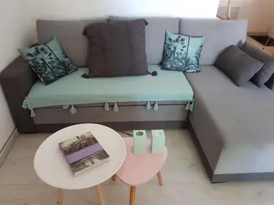 a living room with a couch and a table at vintage home in LʼIsle-sur-la-Sorgue