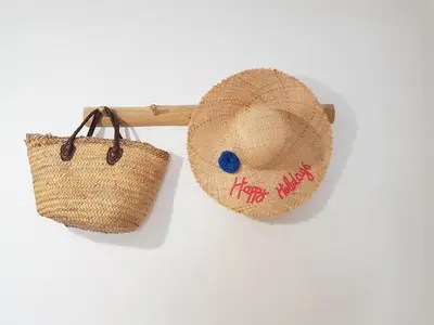 a straw hat and a basket on a wall at vintage home in LʼIsle-sur-la-Sorgue