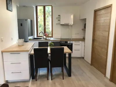 a kitchen with a wooden table and black chairs at Gite au cœur du ventoux in Bédoin
