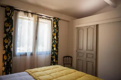 a bedroom with a bed and a window at Bastide Toujours Dimanche, Maison de vacances avec vue & piscine chauffée in Gordes