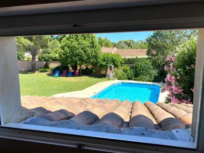 a view of a swimming pool through a window at Villa et maisonnette provençales in Carpentras