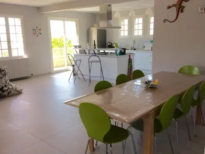 a kitchen with a wooden table and green chairs at Le temps des cerises in Méthamis