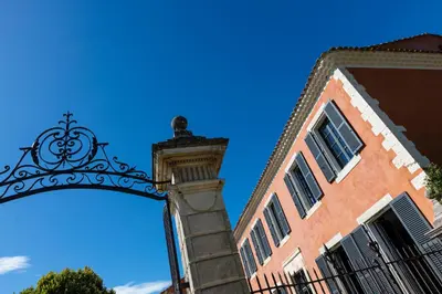 a building with an arch next to a building at Château des Cinq Cantons in Carpentras