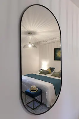 a mirror reflecting a bedroom with a bed at Gite des Demoiselles in Roussillon