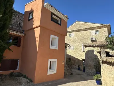 a building with a tower on the side of it at Gite des Demoiselles in Roussillon