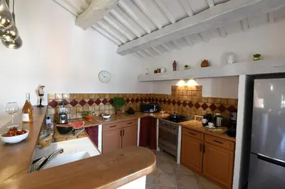 a large kitchen with wooden cabinets and a counter top at Gite des Demoiselles in Roussillon