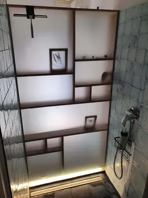a bathroom with a shower with shelves in it at L'Exquishette de Lourmarin, un nid sur les toits. in Lourmarin