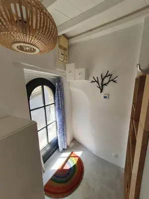 a room with a window and a colorful rug at L'Exquishette de Lourmarin, un nid sur les toits. in Lourmarin