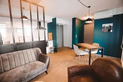 a living room with a couch and a table at Appartement et Garage au Cœur de l'Isle in LʼIsle-sur-la-Sorgue