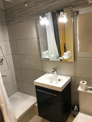 a bathroom with a sink and a toilet and a mirror at Hostellerie Le Mirabeau in Peyrolles-en-Provence