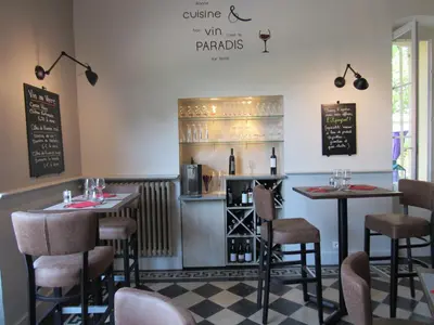 a restaurant with two tables and a counter with wine bottles at Hostellerie Le Mirabeau in Peyrolles-en-Provence