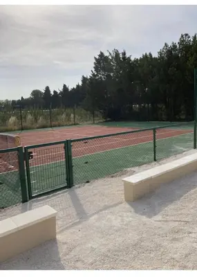 a tennis court with a fence and a tennis court at Mas Galinette in Saint-Andiol