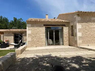 a stone house with a large glass door at Mas Galinette in Saint-Andiol