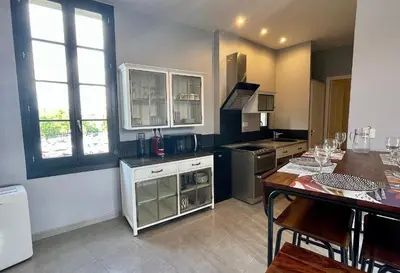 a kitchen with a bar with stools in a room at Quai du Félibre in LʼIsle-sur-la-Sorgue