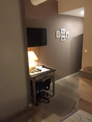 a room with a desk with a television and a lamp at Le jardin in Aix-en-Provence