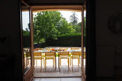 a patio with a table and chairs on a porch at Maison Le Grand Verger in Goult