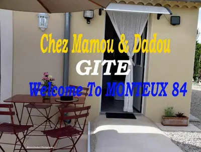 a table with chairs and an umbrella on a patio at Chez Mamou & Dadou in Monteux