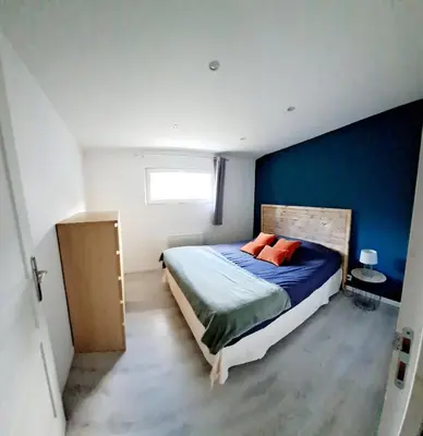 a bedroom with a bed and a blue wall at Gîte 