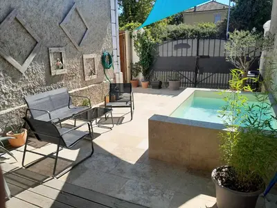 a patio with chairs and a small swimming pool at Gîte 
