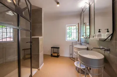 a bathroom with two sinks and a shower at Au Ralenti du Lierre in Beaumettes