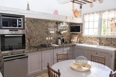 a kitchen with white cabinets and a table with a bowl on it at VILLA PROVENCALE FACE AU LUBERON in Cabrières-dʼAvignon