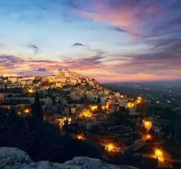 a view of a city at night with lights at VILLA PROVENCALE FACE AU LUBERON in Cabrières-dʼAvignon