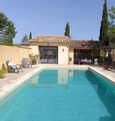 a swimming pool in front of a house at chambre d hotes la dragonne in Maubec