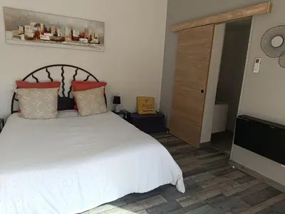 a bedroom with a large white bed with red pillows at chambre d hotes la dragonne in Maubec