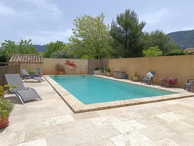 a swimming pool in a yard with chairs around it at chambre d hotes la dragonne in Maubec