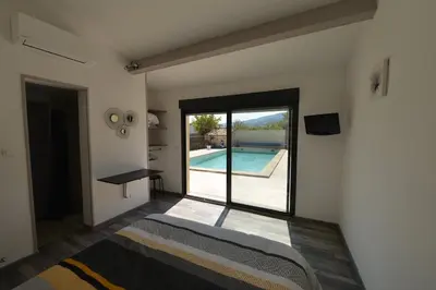 a bedroom with a view of a swimming pool at chambre d hotes la dragonne in Maubec