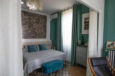 a bedroom with green walls and a bed with blue pillows at La maison Gerval in Bédoin