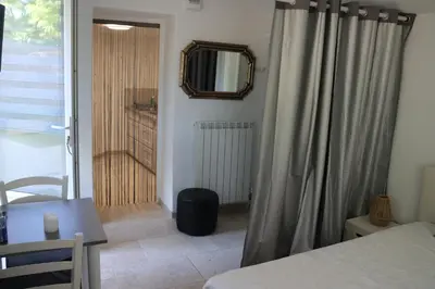 a bedroom with a bed and a table and a mirror at Les BRUNS in Saignon