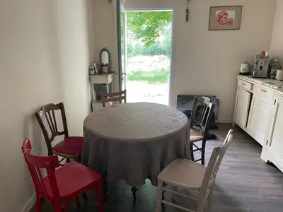 a kitchen with a table and chairs and a window at SOUS LE TILLEUL CENTENAIRE in La Tour-dʼAigues