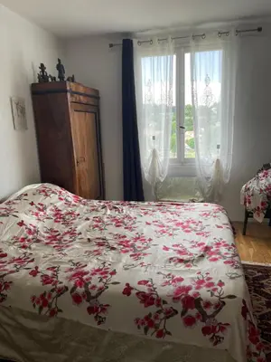 a bedroom with a bed with red flowers on it at SOUS LE TILLEUL CENTENAIRE in La Tour-dʼAigues
