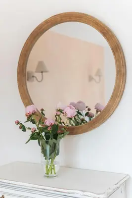 a vase of flowers on a table with a mirror at La Petite Ruche, 1 bedroom Gite in the Luberon in Apt