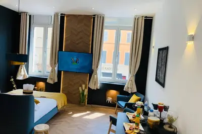 a bedroom with a bed and a living room at Suite Le CEZANNE in Aix-en-Provence